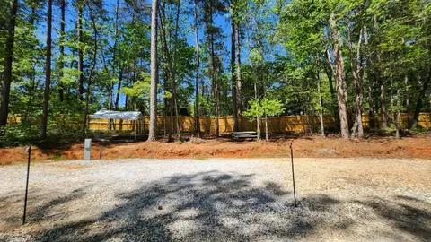 Campsite #6 RV/ Tent  Site Full Hook Up, 60’ x 18’ Level Gravel Pad with Back Yard and Shaded Fenced Enclosure for your Pets, Pull Through — image 1 of 11